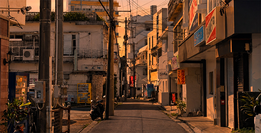夕日に染まる商店の並ぶ路地